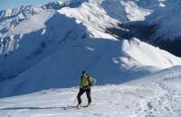 Turystka na nartach skiturowych podchodzi na Kopę Kondracką. W tle Kasprowy Wierch.Fot. Agnieszka Szymaszek